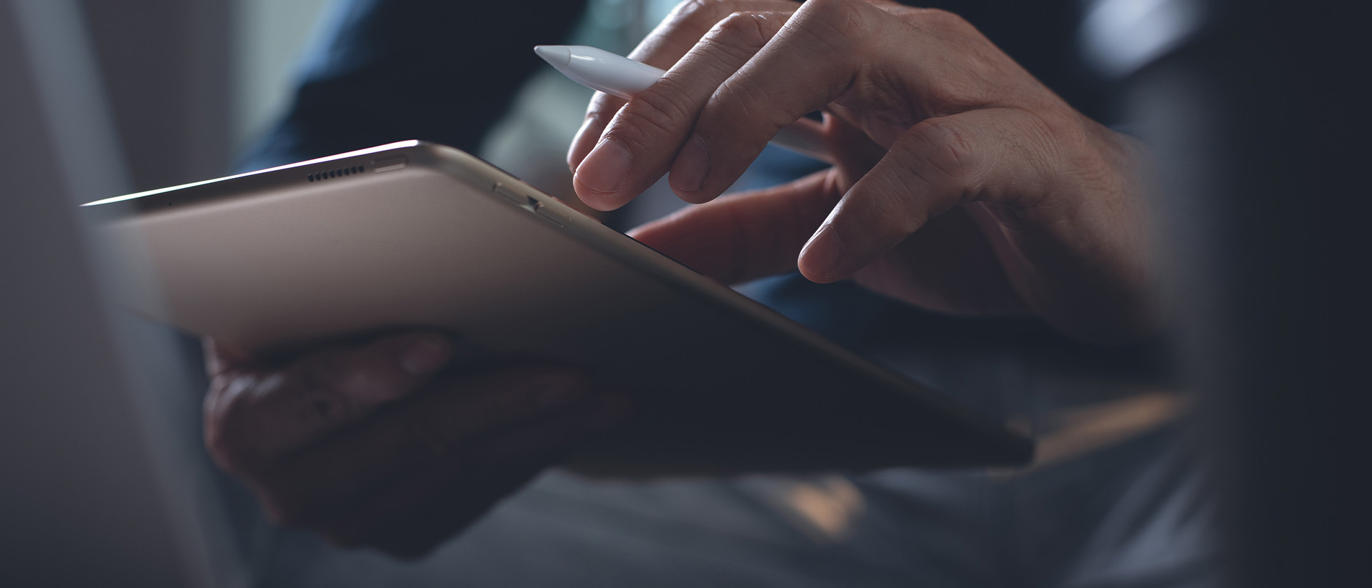 OrangeLogic Header 2 hands holding tablet and pen